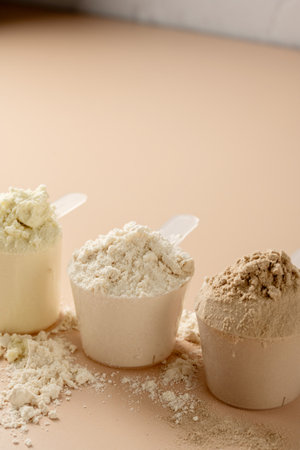 Protein powder in scoops. Different flavours of whey protein powder, copy space