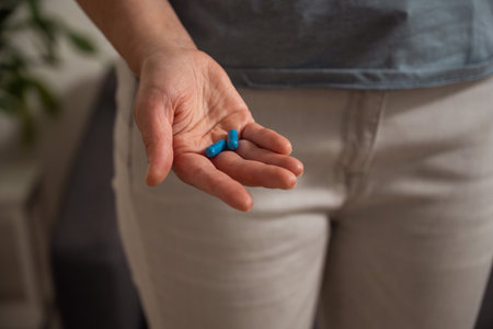 Woman holding blue pills in hand. Health care, dietary supplements, treatment of depression and...