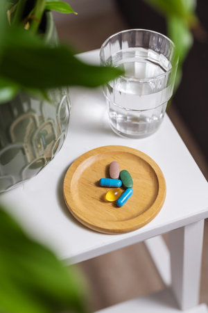 Colourful pills with glass of water on the table, lifestyle shot