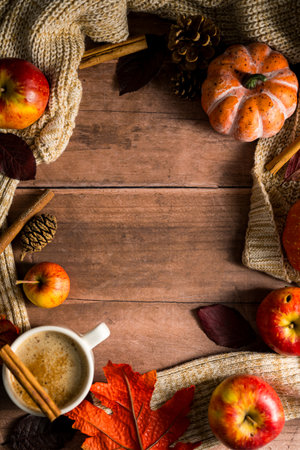 Hot drink frame, cosy autumn coffee drink, with apples and cinnamon, orange pumpkins, wooden rustic...