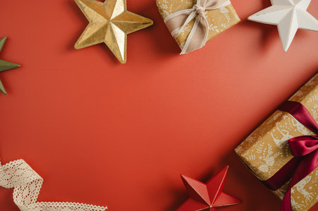 Christmas red background, flat lay composition with gifts and festive decorative stars, copy spaceの写真素材