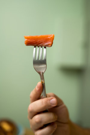 Salmon fillet slice on fork, healthy food concept, eating proteinsの写真素材