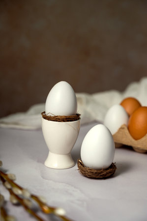 Easter spring background. Egg in ceramic egg holder, with willow pussy branch. Minimalistic
