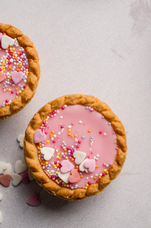 Valentine's day dessert. Pink mini tarts with heart shaped sprinkles. Top viewの写真素材