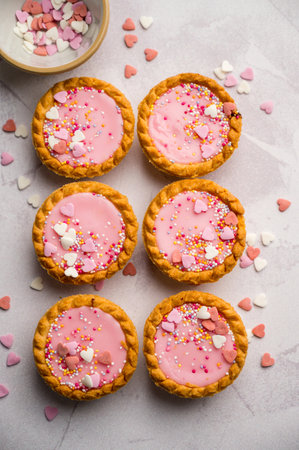 Valentine's day dessert. Pink mini tarts with heart shaped sprinkles. Top viewの写真素材