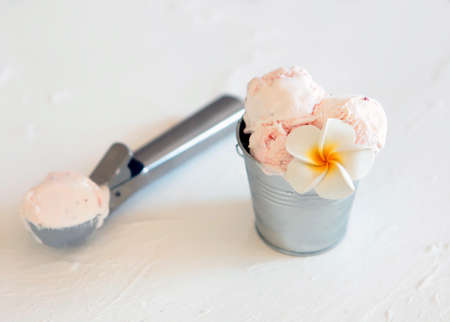 Pink ice cream with a spoon and metal bucket