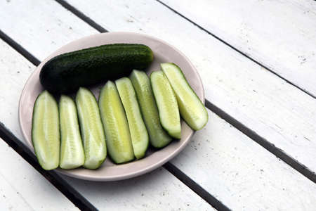 Cucumber on wooden table at the plate and vintage background. Selective focus on cucumberの写真素材
