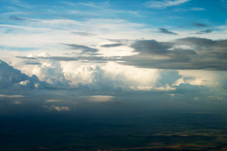 blue sky background with white clouds. Puffy clouds on the horizon. View from the airplane window.