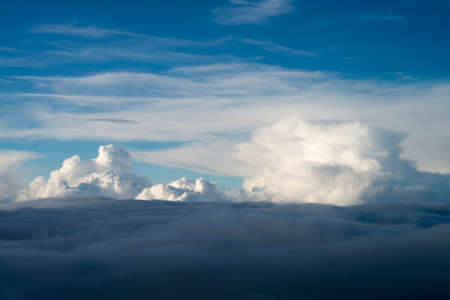 blue sky background with white clouds. Puffy clouds on the horizon. View from the airplane window.