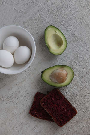 Tasty sandwich with avocado, tomato and poached egg on concrete , close up. Healthy delicious...