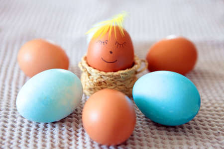 Colorful Easter eggs with smiling emoticon for handpaintings at home. brown eggs face arranged...