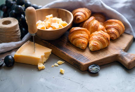 Original tasty French croissants with cheese and grapes on the wooden table. buttery flaky...