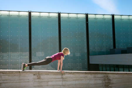 Sporty young girl in top and leggings doing yoga streching exercise pose. Pretty woman holding hands...