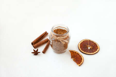 Cinnamon sticks and star anise on brown sugar with shallow depth of field on white background....