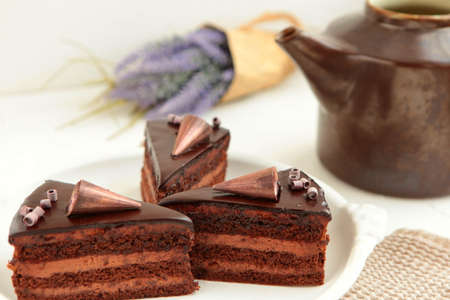 Chocolate cake slice with curl on white