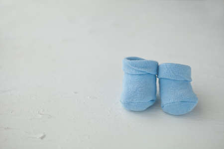 Blue baby socks on a textured rustic background with copy space. Newborn and pregnancy concept.の写真素材