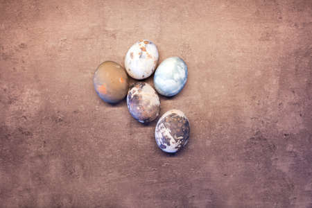 Happy Easter eggs with marble stone effect painted with natural grey concrete background with blank space for text. top view, flat layの写真素材