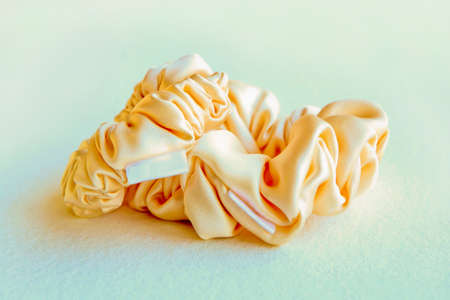 yellow silk scrunchyes on gray background. Hairdressing tools and accessories - Hair Scrunchies,...