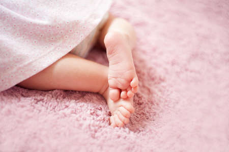 Feet of newborn baby girl. fingers on the foot, maternal care, love and family hugs, tenderness. newborn baby girl legsの写真素材