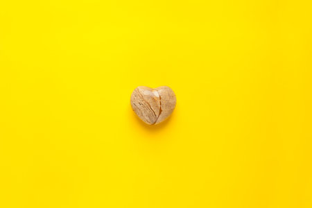 A top view image of a yellow heart shaped -stone heart on a yellowの写真素材