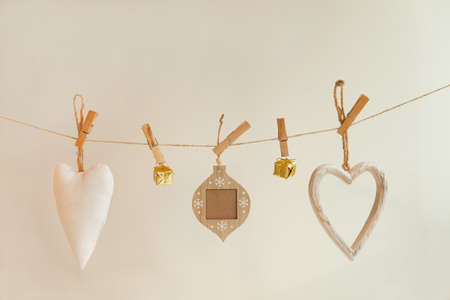 white and golden christmas decorations pinned on rope. Fabric and textile ornament hanging on whiteの写真素材