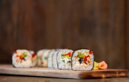hot roll set sashimi japanese food on wooden background with lemon and chopsticksの写真素材