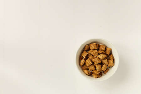 bowl with muesli on white background. delicious breakfast with flakes served in a white ceramic bowlの写真素材