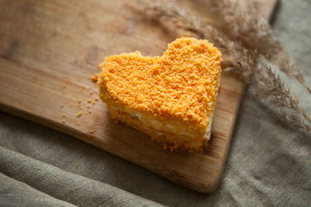 Valentines day dessert-heart shape orange carrot cake on calm brown background. Minimalistic imageの写真素材