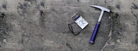 banner-geology mine exploration with compass on stone and hammer. science concept. geologist chisel