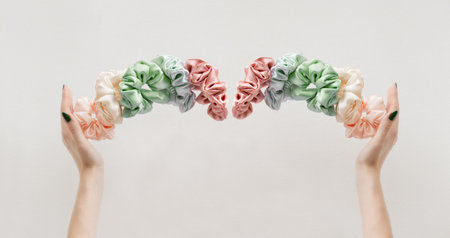 womas hands holding colorful scrunchies like crown on white banner. Elastic HairBands levitation