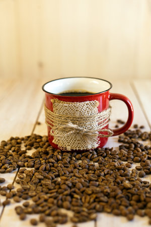 red cup and roasted coffee beans on wooden background.の写真素材