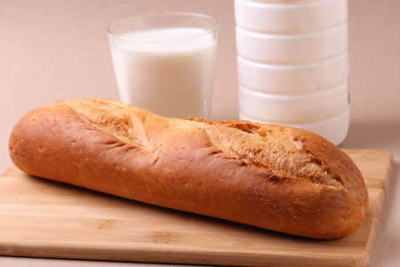french baked pastry croissants and a glass of milk on rustic beige background