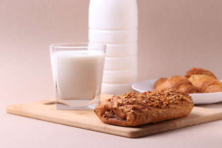 french baked pastry croissants and a glass of milk on rustic beige backgroundの写真素材