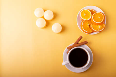 orange and cinnamon aroma candles on yellow.の写真素材