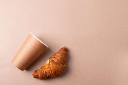 a cardboard cup and a croissantの写真素材