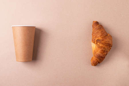 a cardboard cup and a croissantの写真素材