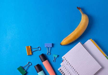 different stationary items and notebooks on the blue background. minimalism. flat layの写真素材