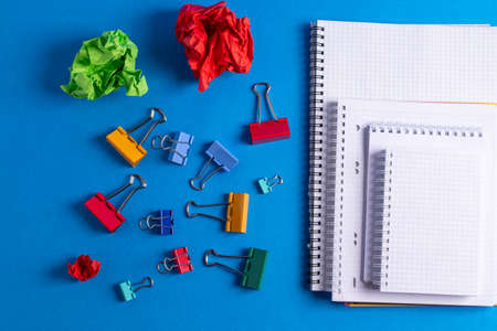 different stationary items and notebooks on the blue background. minimalism. flat lay