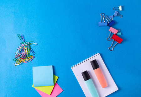 different stationary items and notebooks on the blue background. minimalism. flat lay
