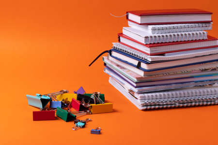 different stationary supplies items on orange office or studying desk
