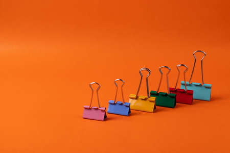 different stationary supplies items on orange office or studying deskの写真素材