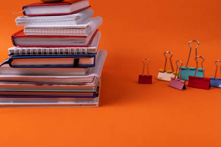different stationary supplies items on orange office or studying desk