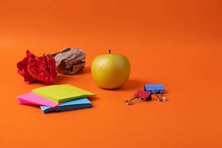 different stationary supplies items on orange office or studying desk
