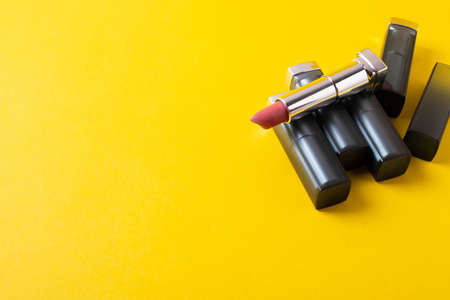 female bright lipsticks on mono colour yellow background