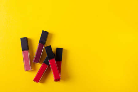 female bright lipsticks on mono colour yellow background