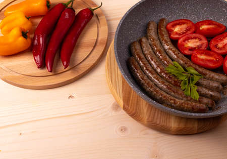 fried natural beef sausage and tomatoes