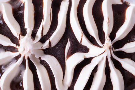 delicious creamy milky vanilla ice cream with caramel and chocolate addings in a glass container on...