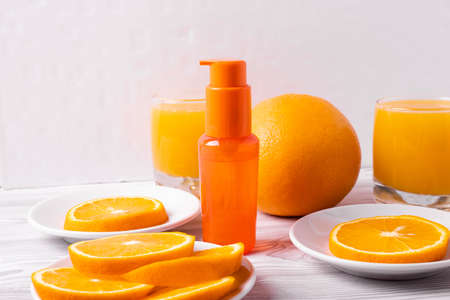 glasses of orange juice and fresh sliced oranges on ligh wooden surface. top view, minimalism styleの写真素材