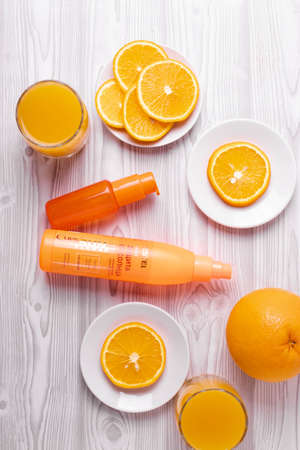 glasses of orange juice and fresh sliced oranges on ligh wooden surface. top view, minimalism style