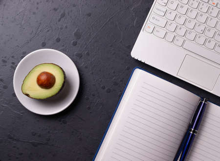 a white laptop and open notebook on the grunge stone concrete surface